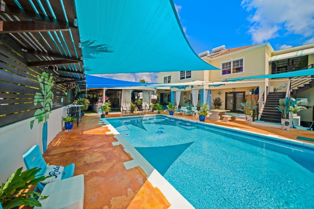 The pool and shaded courtyard at Hidden Gem Barbados, with the residence beyond