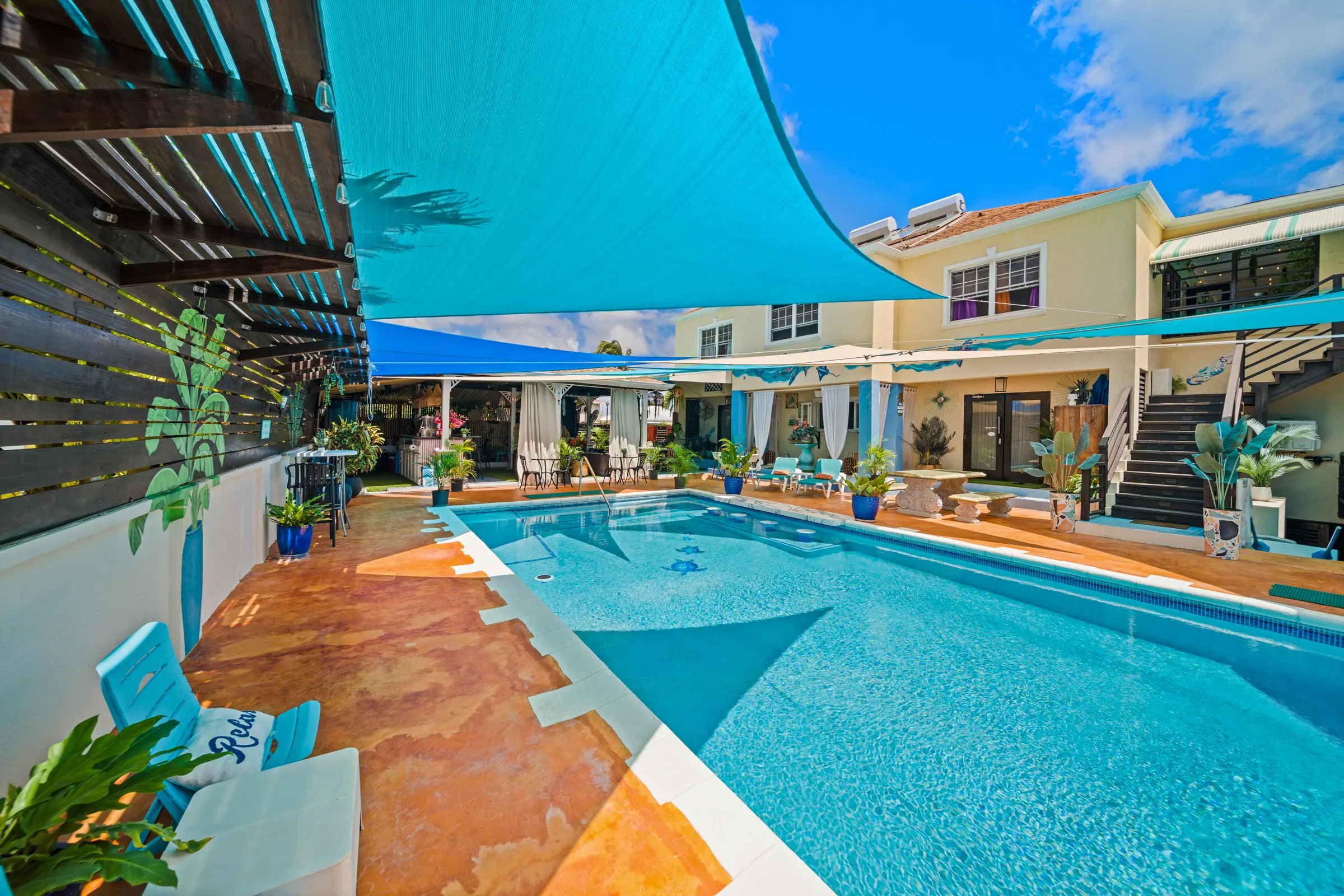 The pool and shaded courtyard at Hidden Gem Barbados, with the residence beyond