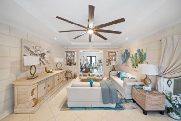 The open-plan living room at Hidden Gem Barbados, with coral stone walls and pale linen seating