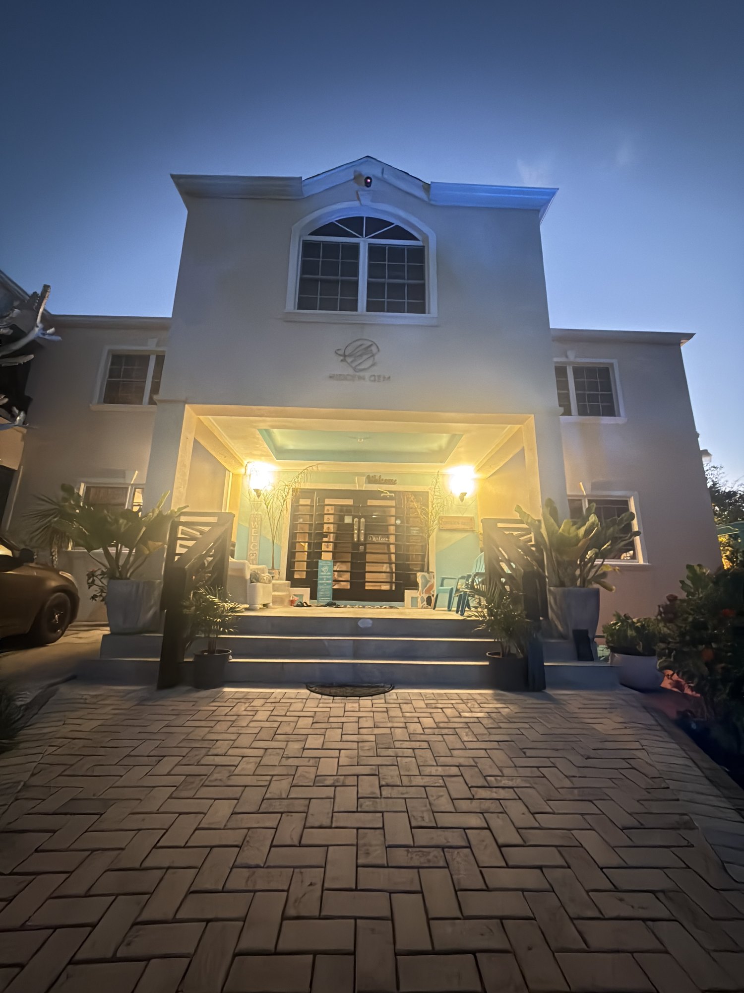The lit entrance to Hidden Gem Barbados in the evening