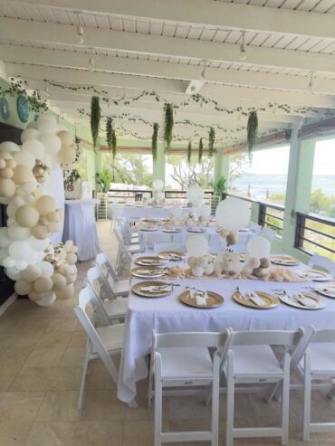A celebration table dressed with balloons and white linen at Hidden Gem Barbados