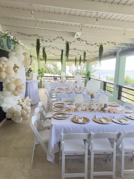 A celebration table dressed with balloons and white linen at Hidden Gem Barbados