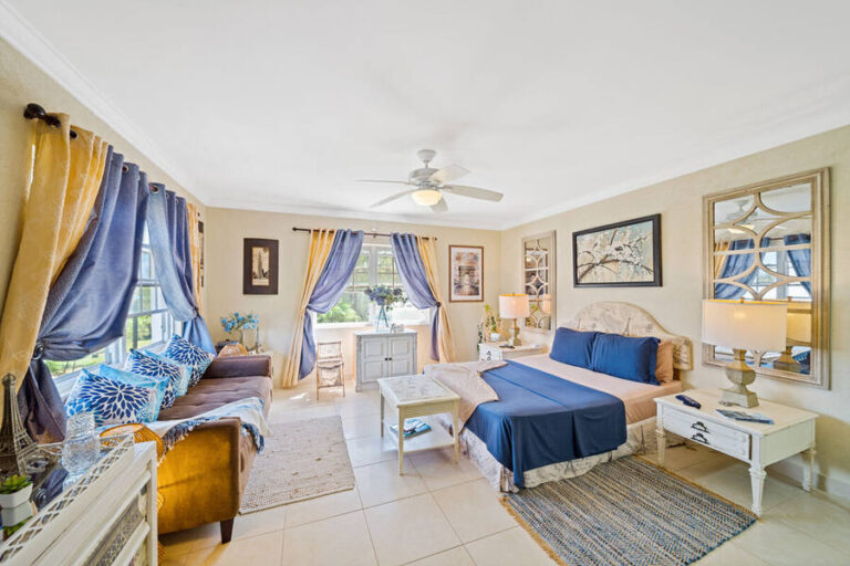 The Parisian Room at Hidden Gem Barbados, a blue and white bedroom with a seating area